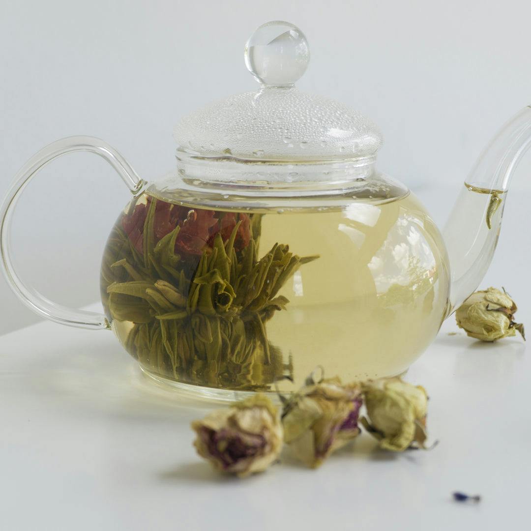 Teiera di vetro con fiore di tè in infusione